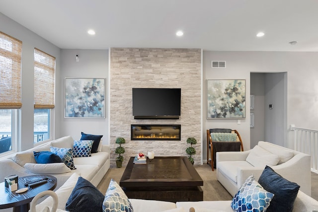 carpeted living room featuring a wealth of natural light and a fireplace