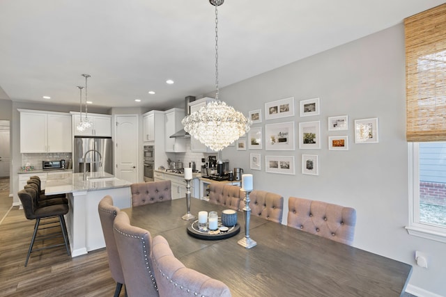 dining space featuring a notable chandelier, dark hardwood / wood-style flooring, and sink