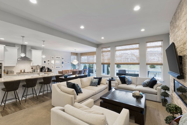 living room with a fireplace, a healthy amount of sunlight, dark hardwood / wood-style floors, and an inviting chandelier