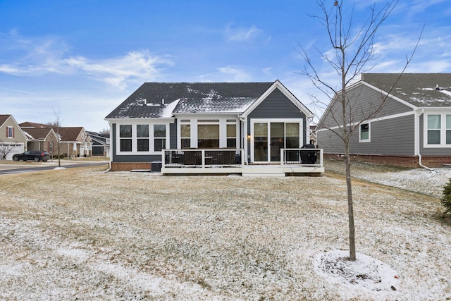 back of property featuring a deck and a sunroom