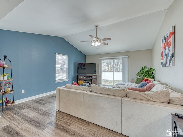 living room featuring ceiling fan, wood-type flooring, and vaulted ceiling