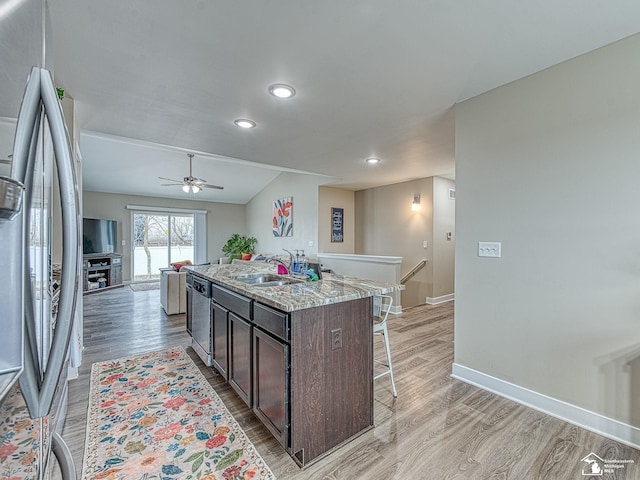 kitchen with hardwood / wood-style flooring, a center island with sink, dark brown cabinets, and appliances with stainless steel finishes