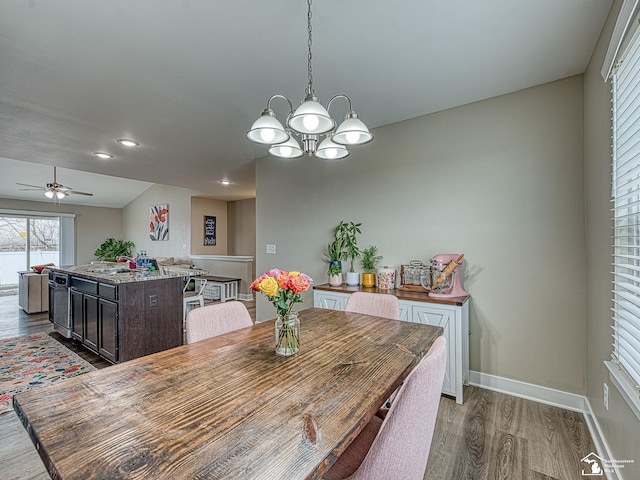 dining room with hardwood / wood-style floors and ceiling fan with notable chandelier