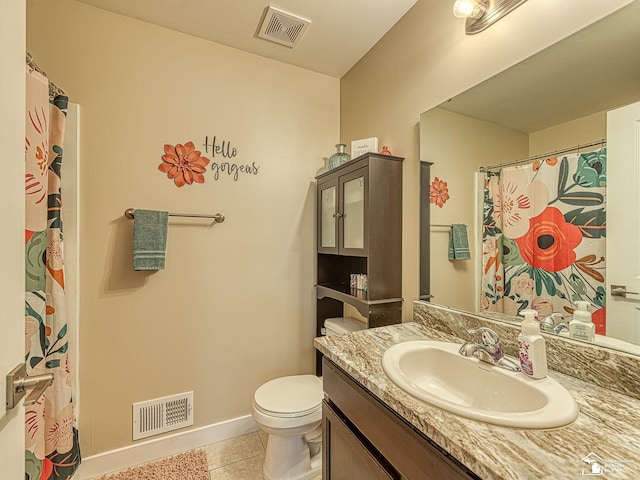 bathroom with tile patterned flooring, vanity, and toilet