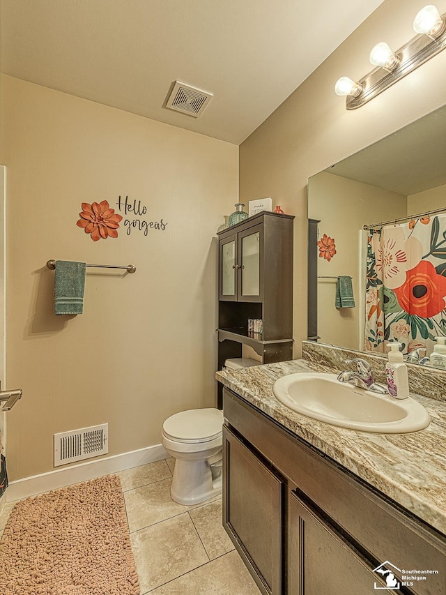 bathroom with tile patterned flooring, vanity, and toilet