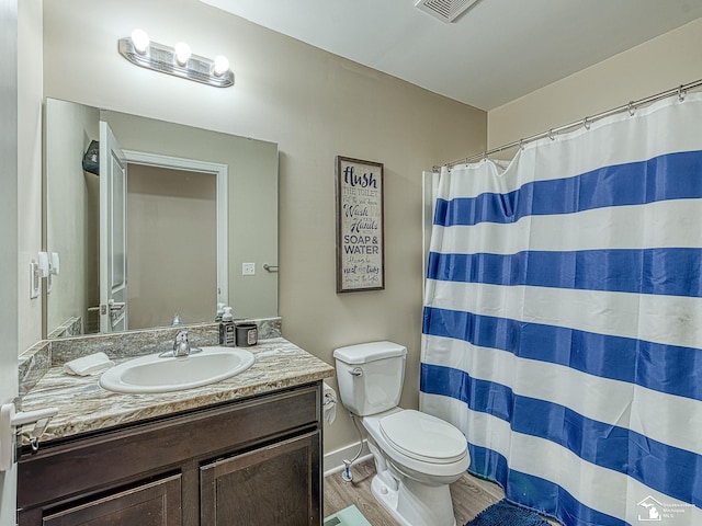 bathroom featuring hardwood / wood-style floors, vanity, curtained shower, and toilet