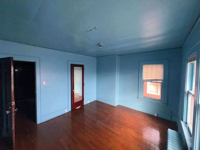 empty room featuring radiator and wood finished floors