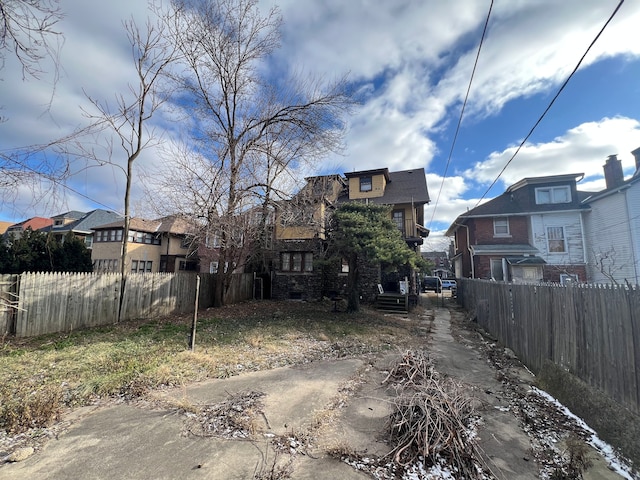 exterior space with a fenced front yard, a residential view, and brick siding