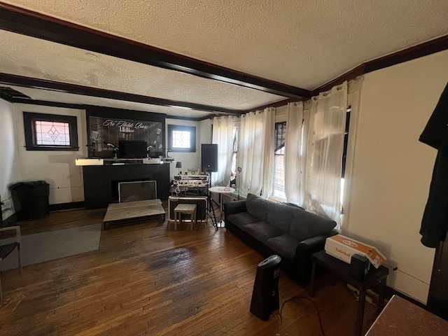 living area featuring beam ceiling, a fireplace, a textured ceiling, and hardwood / wood-style floors