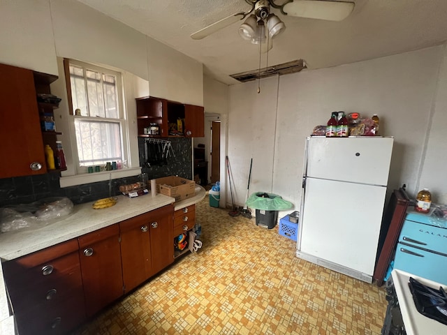 kitchen with a ceiling fan, open shelves, freestanding refrigerator, light countertops, and light floors