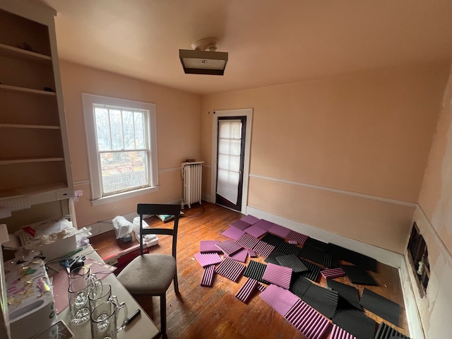 interior space featuring radiator heating unit, baseboards, and wood finished floors