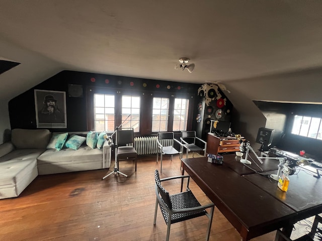 interior space with wood-type flooring, radiator, and vaulted ceiling