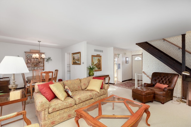 carpeted living room featuring a notable chandelier