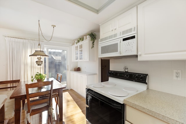 kitchen with decorative backsplash, ornamental molding, white appliances, white cabinets, and hanging light fixtures