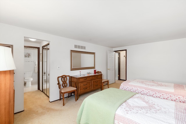 carpeted bedroom featuring ensuite bathroom