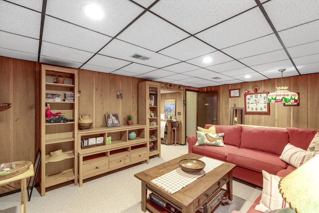 carpeted living room featuring wooden walls