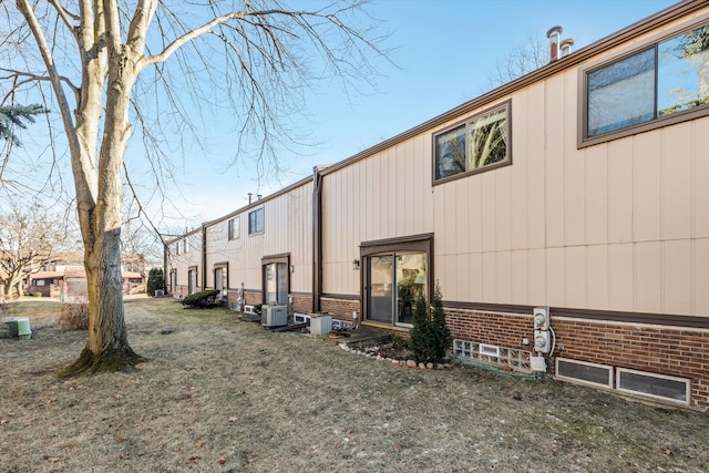 view of home's exterior featuring central air condition unit and a yard