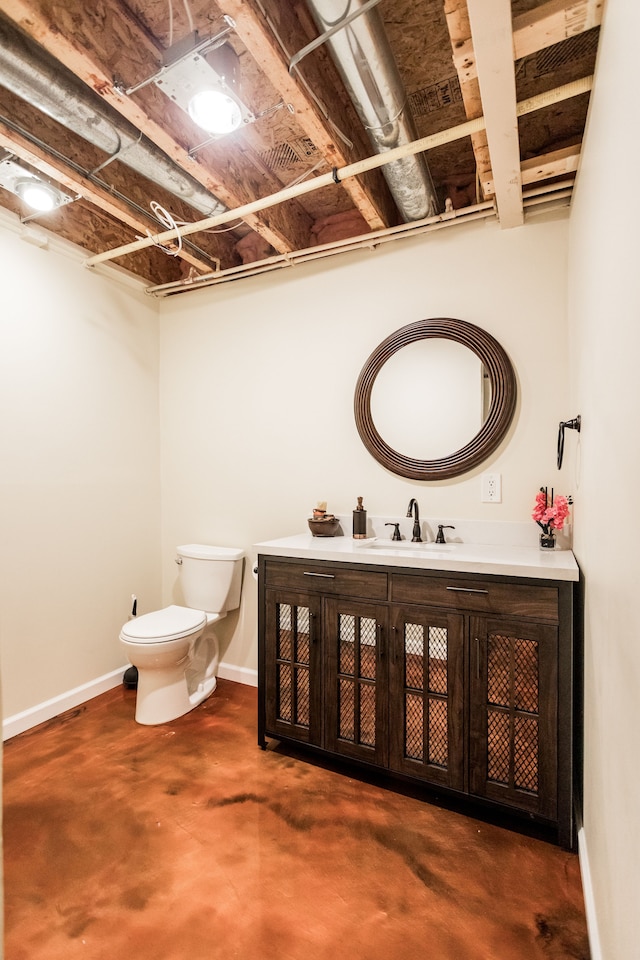 bathroom featuring concrete flooring, vanity, and toilet