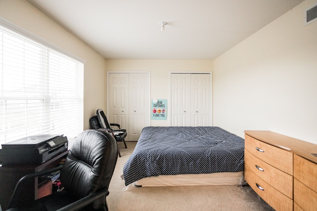 carpeted bedroom featuring two closets