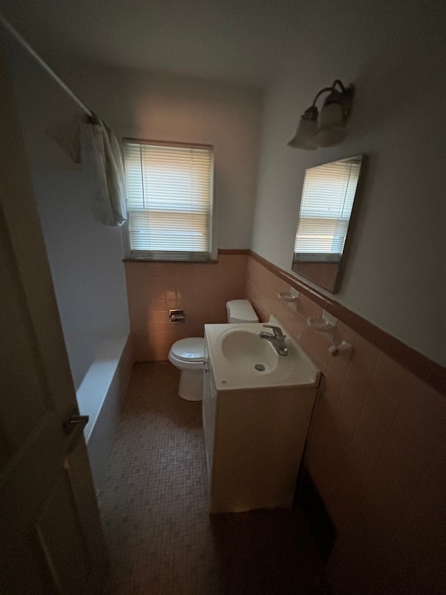 full bathroom with vanity, toilet, tile walls, and shower / bath combo with shower curtain