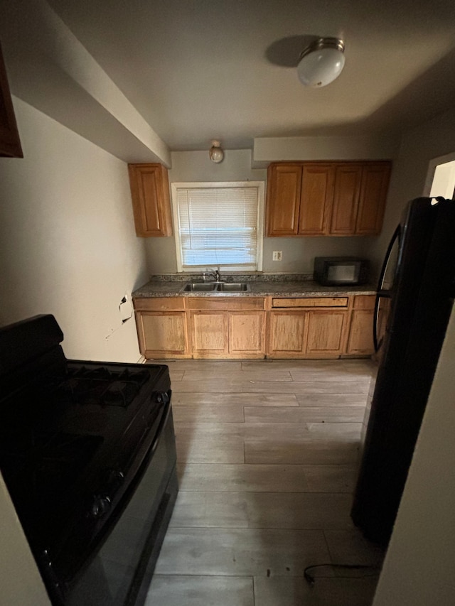 kitchen featuring light hardwood / wood-style flooring, refrigerator, sink, and black / electric stove