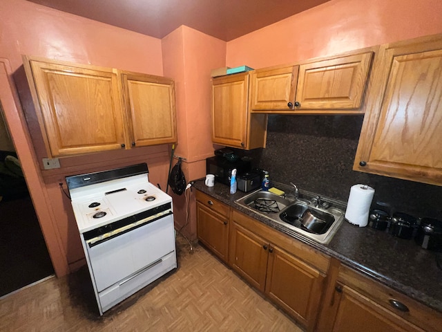 kitchen with decorative backsplash, dark stone counters, light parquet floors, sink, and white stove