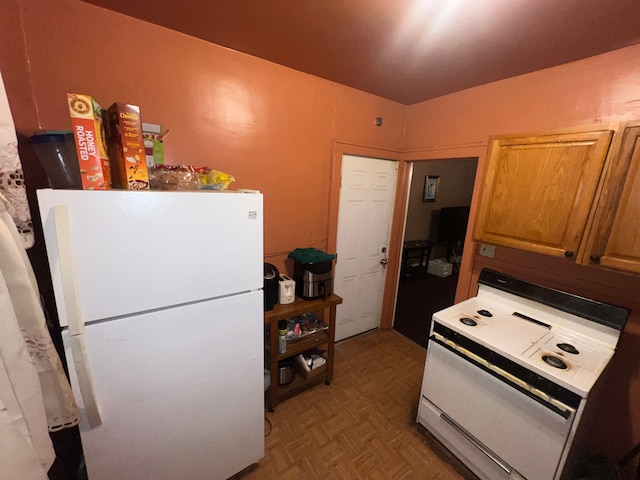 kitchen featuring white appliances and parquet flooring