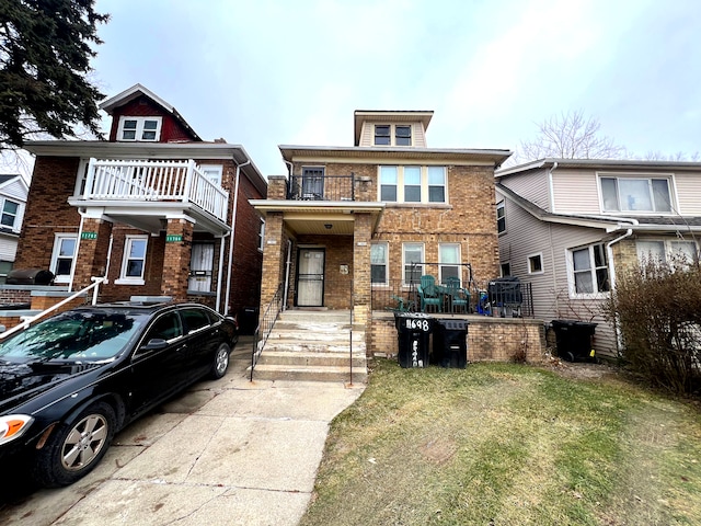 view of front of house featuring a balcony and a front lawn