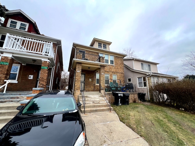 view of front of house with a balcony and a front yard