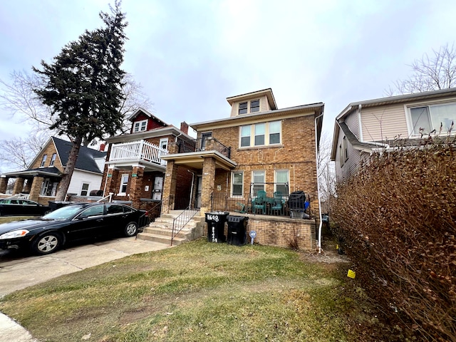 view of front of home with a balcony and a front lawn