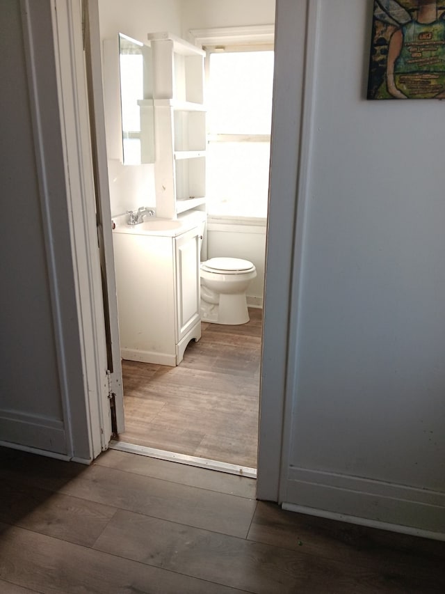 bathroom featuring hardwood / wood-style flooring, toilet, and vanity