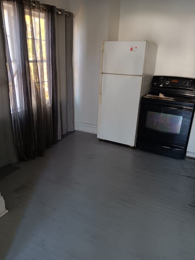 kitchen with white fridge, black range with electric cooktop, and wood-type flooring