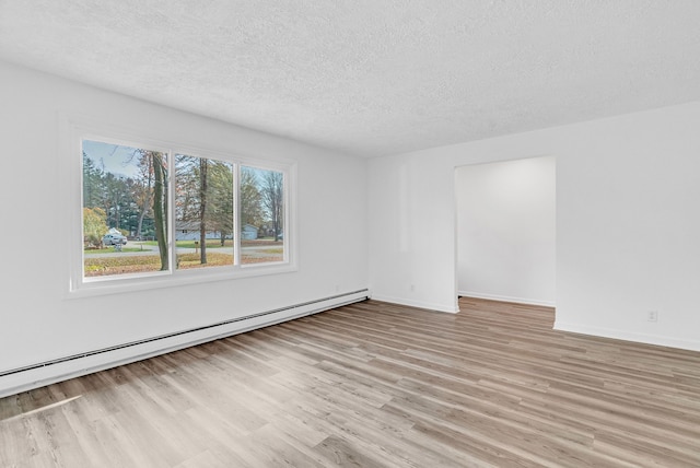 unfurnished room featuring a textured ceiling, light hardwood / wood-style flooring, and a baseboard radiator