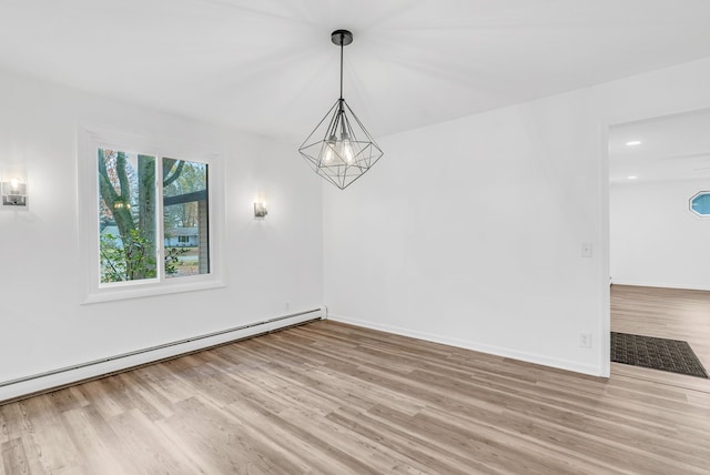 unfurnished dining area featuring light hardwood / wood-style floors and a baseboard heating unit