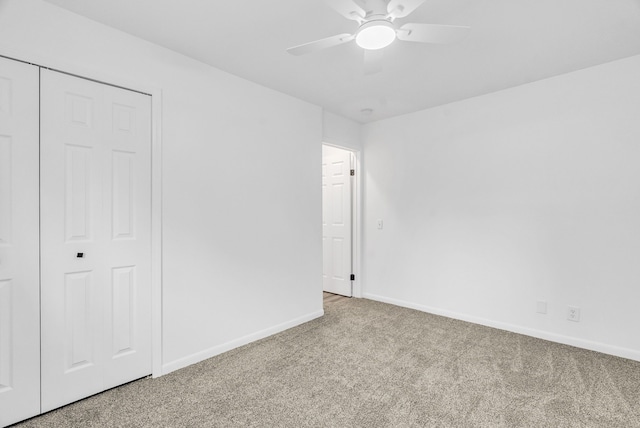 unfurnished bedroom featuring ceiling fan, a closet, and light colored carpet