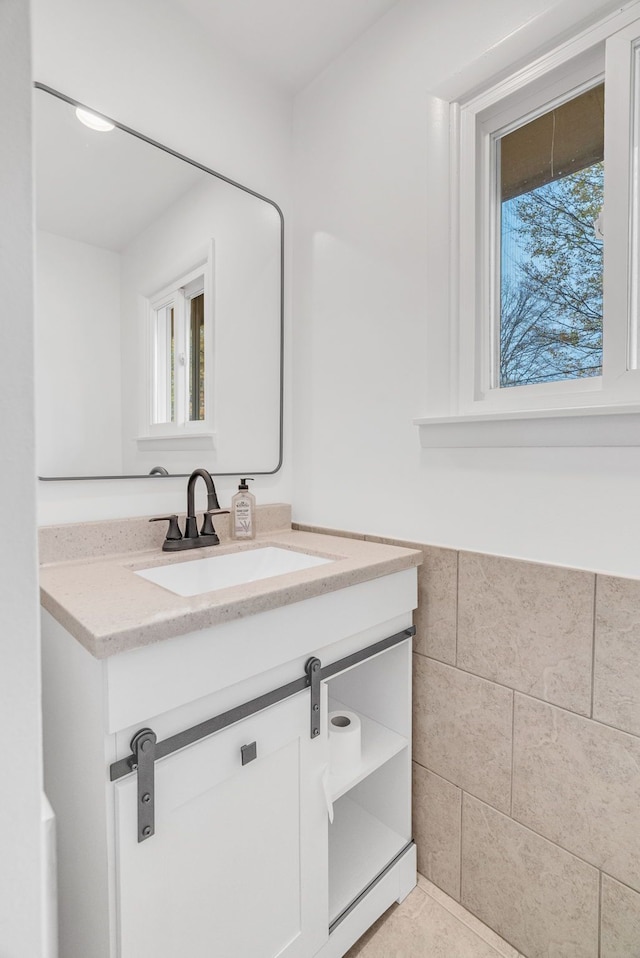 bathroom with tile patterned floors, vanity, and tile walls