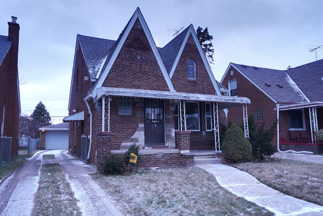 view of front of property featuring a porch, a garage, and an outdoor structure