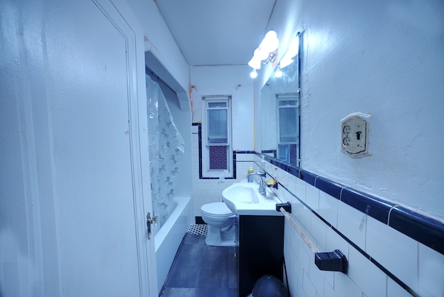 full bathroom featuring shower / tub combination, vanity, tile walls, and toilet