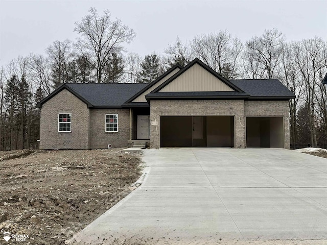 view of front of property with a garage, roof with shingles, concrete driveway, and brick siding