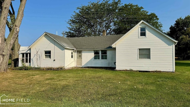 rear view of property featuring a lawn