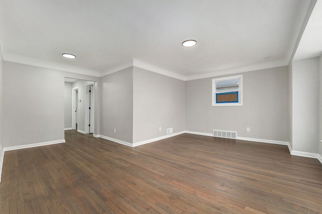 spare room featuring dark hardwood / wood-style flooring and ornamental molding