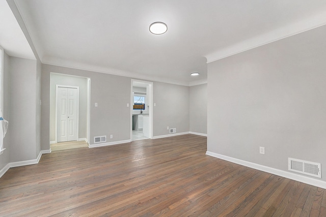 spare room featuring crown molding and dark hardwood / wood-style flooring