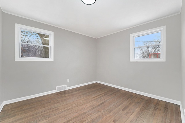 empty room with crown molding and dark wood-type flooring