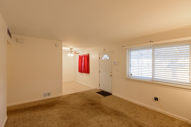 carpeted foyer entrance with ceiling fan