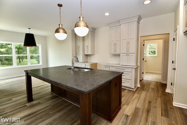 kitchen with a sink, baseboards, dark wood finished floors, recessed lighting, and white cabinets