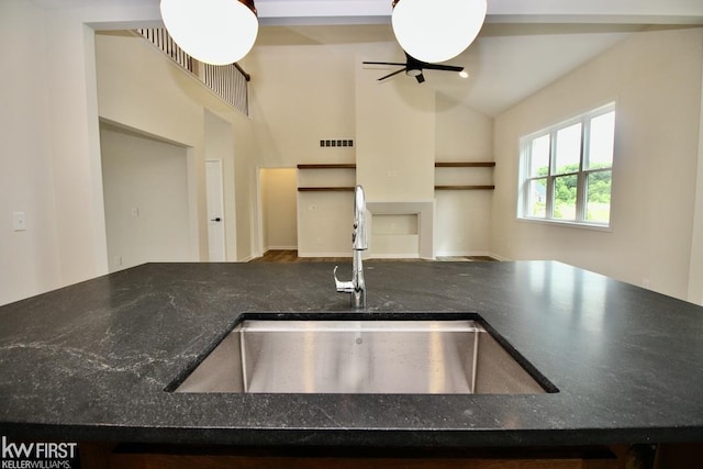 kitchen with a sink, ceiling fan, and lofted ceiling