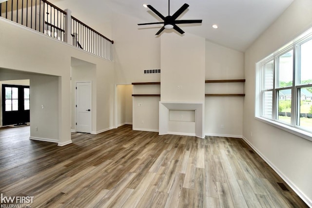 unfurnished living room featuring high vaulted ceiling, plenty of natural light, ceiling fan, baseboards, and recessed lighting