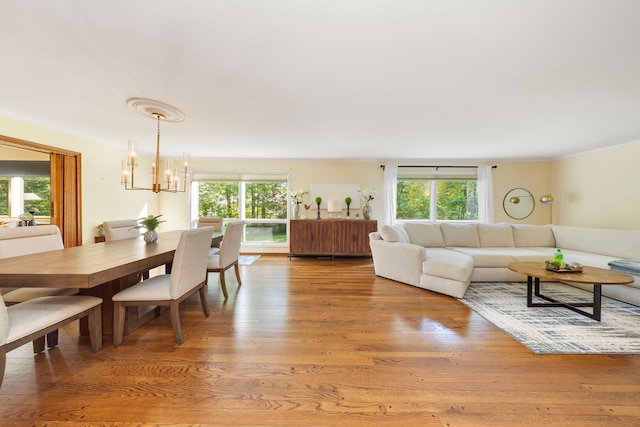 living room with light hardwood / wood-style floors, a wealth of natural light, and an inviting chandelier