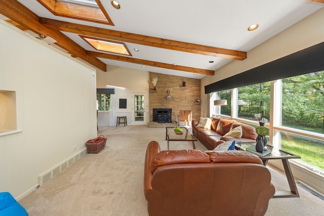 carpeted living room featuring a wood stove and lofted ceiling with skylight