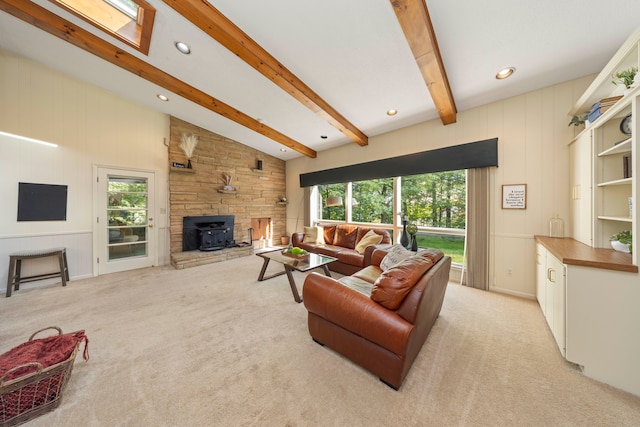 living room with a wood stove, a wealth of natural light, lofted ceiling with beams, and light carpet